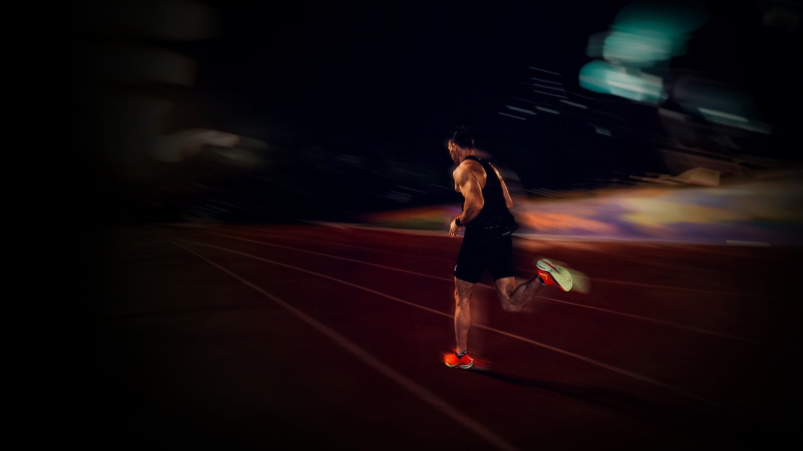 Norman Petermann running on a track at night