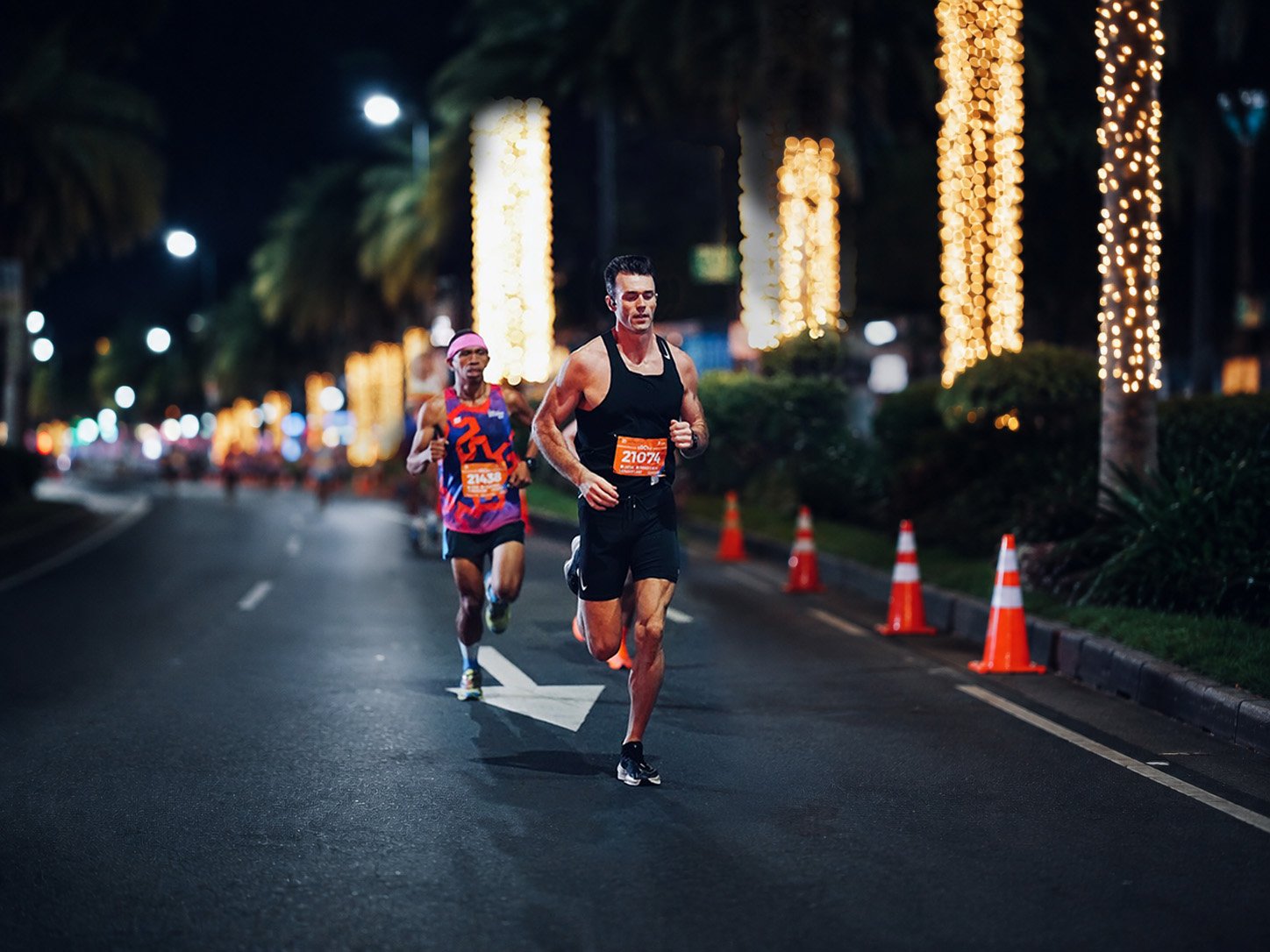 Norman Petermann running in a night race under illuminated palm trees