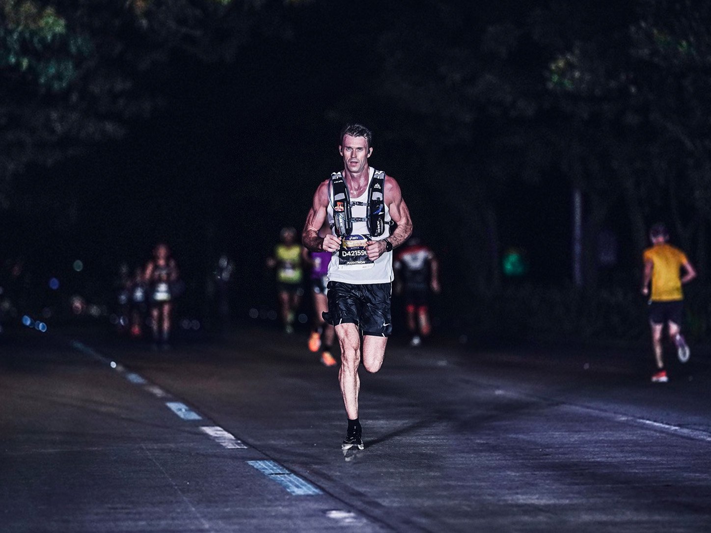 Norman Petermann running alongside another runner during a night race