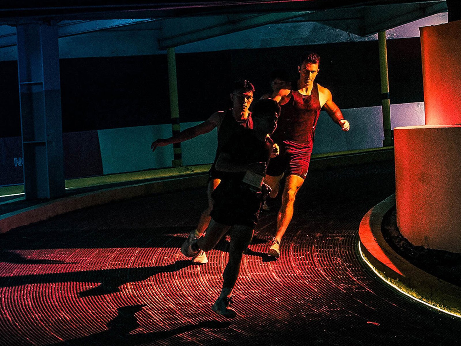 Runners moving through a curve at night